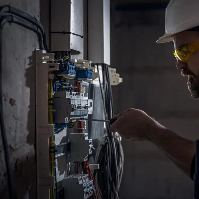 Técnico fazendo manutenção em quadro elétrico